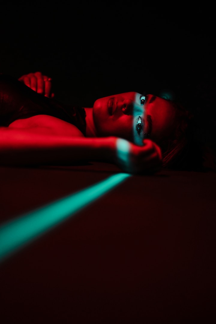 Woman lies in red light with a green stripe.